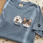 Custom dog and cat portrait embroidered T-shirt in blue with pet names and a paw print sleeve detail