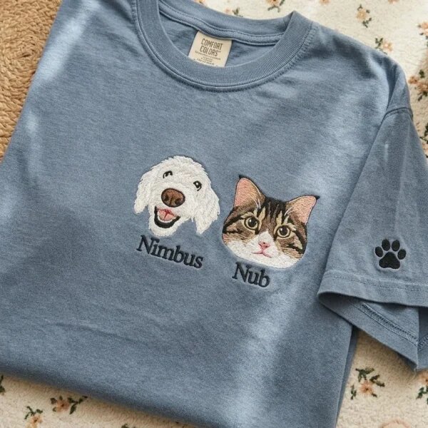 Custom dog and cat portrait embroidered T-shirt in blue with pet names and a paw print sleeve detail