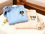 Light blue Milo dog portrait sweatshirt beside a cream Ace and Kitty dog-and-cat portrait sweatshirt