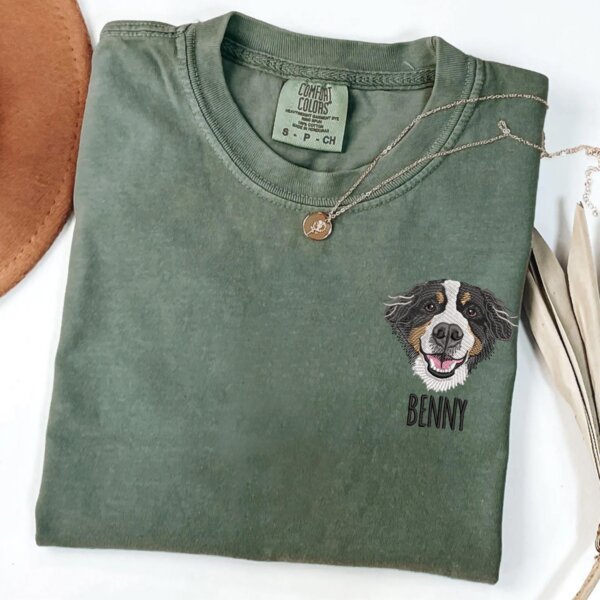 Custom dog face embroidered T-shirt with the pet name Benny on a green shirt