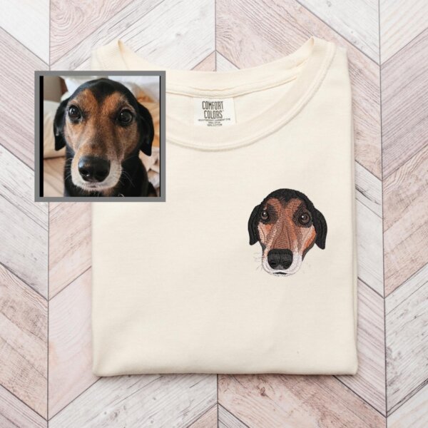 Custom embroidered black and tan dog portrait on an ivory T-shirt beside the original pet photo