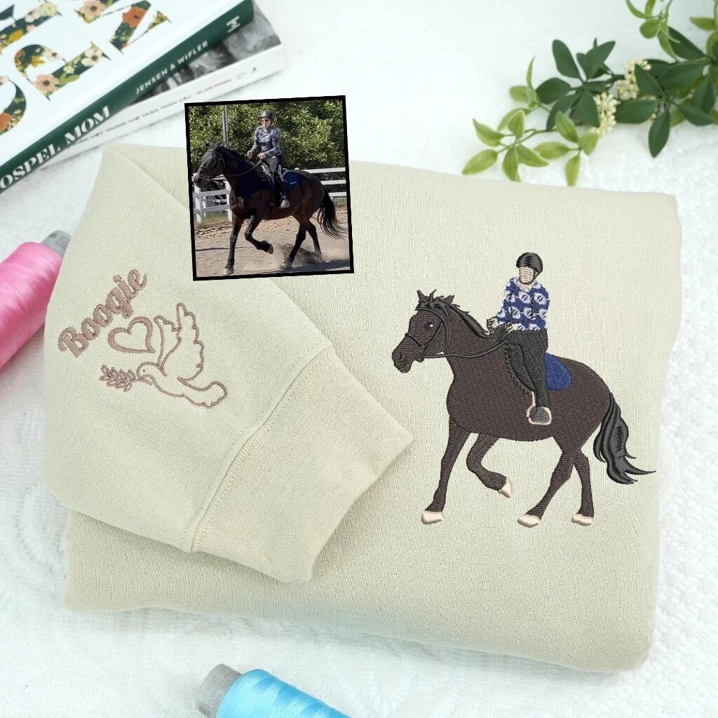 Custom Embroidered Dressage Horse Portrait Sweatshirt in Sand – Personalized Memorial Sand colored crewneck sweatshirt featuring custom embroidered dressage horse and rider with sleeve embroidery name Boogie and dove heart icon