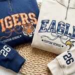 Tigers and Eagles school mascot quarter-zip pullovers with gingham lettering, mascot logos and sleeve year