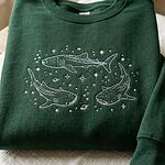 Dark forest green sweatshirt with intricate white thread embroidered whale sharks, stars, and marine motifs