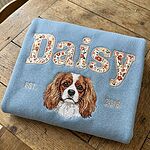 Light blue Daisy custom dog portrait sweatshirt with floral varsity name, EST. 2018, and embroidered pet face