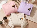 Pink, lavender, and cream personalized pet portrait sweatshirts showing one dog, one cat, and two dogs