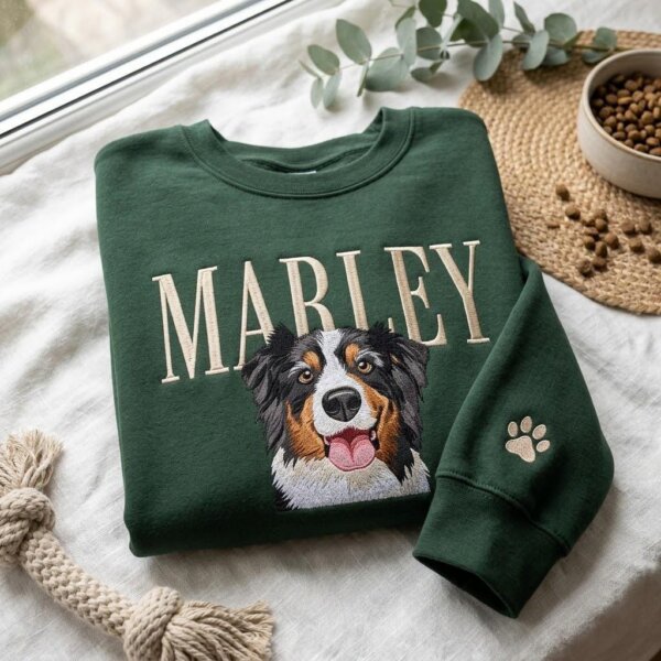 Green personalized dog photo embroidery sweatshirt with Marley name and paw print sleeve in a flat lay