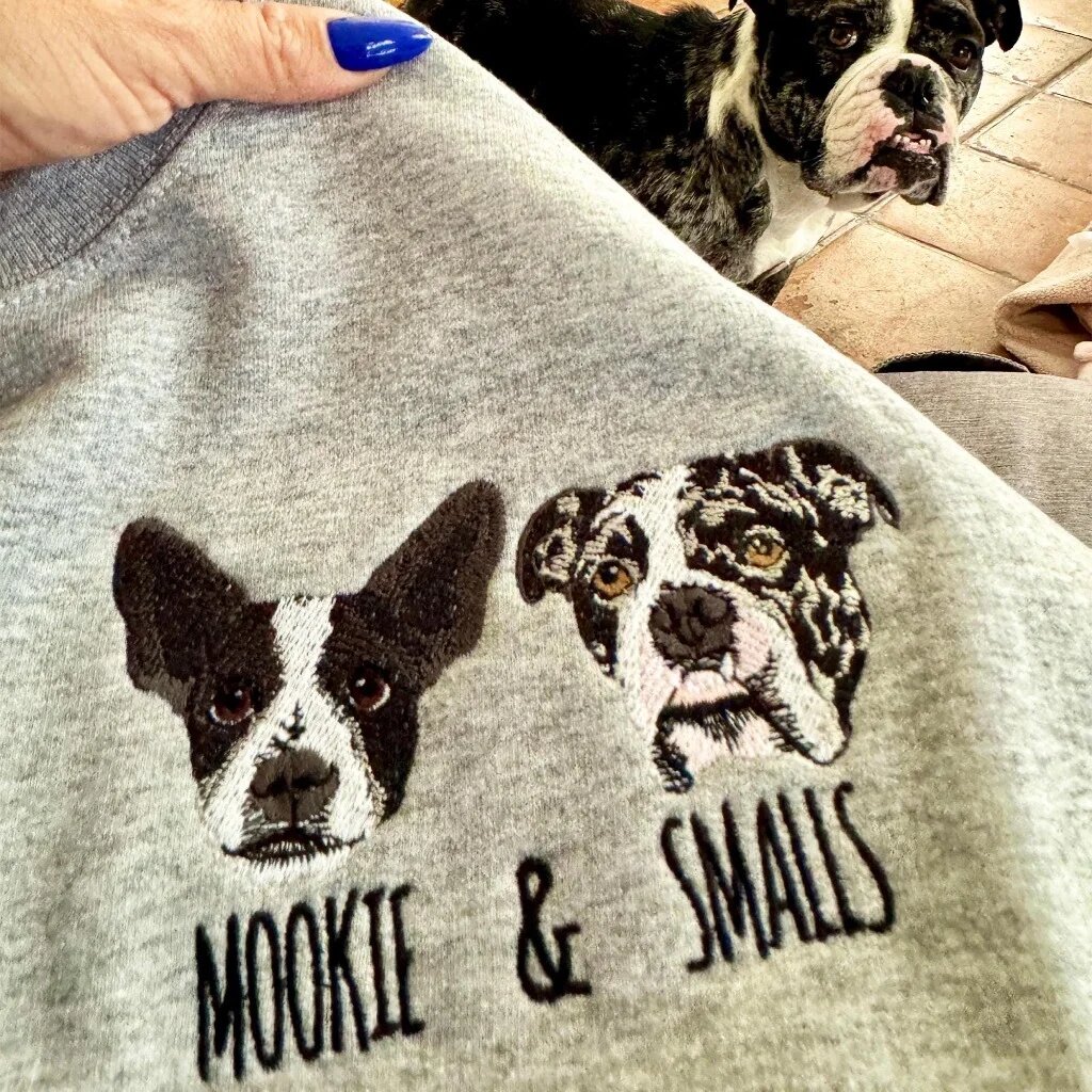 Personalized Two Dog Face Embroidered Crewneck Sweatshirt – Mookie & Smalls Sport grey crewneck sweatshirt featuring custom embroidered two dog faces with Mookie and Smalls text and pet in background