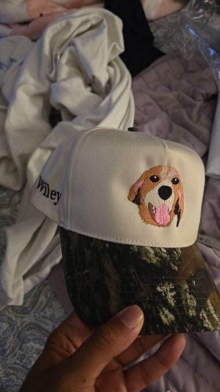 Customer photo of a white cap with a brown-and-white embroidered dog portrait and camouflage brim