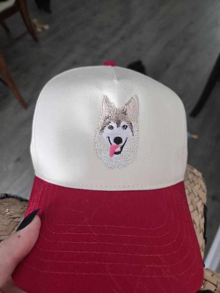 Customer photo of a cream and red cap with an embroidered light-colored dog portrait