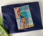 Navy blue folded t-shirt featuring vibrant custom embroidery of an earth ice cream cone and There Is No Planet B postal stamp graphic