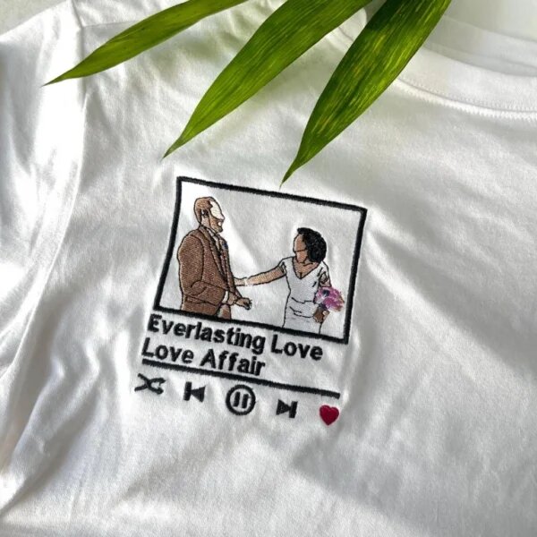 White custom embroidered t-shirt showcasing a wedding couple portrait in polaroid frame with Everlasting Love music player bar and heart icon