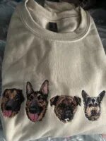 Customer photo of sand beige crewneck sweatshirt featuring four custom embroidered dog face portraits in realistic needlework