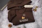 Espresso brown embroidered pullover hoodie displaying centered sleepy pixel chicken with sleep bubble and I'm starting to feel exhausted embroidery