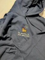 Navy blue pullover embroidered hoodie with drawstrings displaying centered sleepy pixel chicken and tired quote embroidery