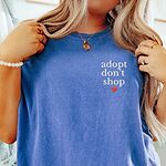Woman in a Flo Blue T-shirt embroidered with adopt don't shop in white stacked letters and a small red heart on the left chest