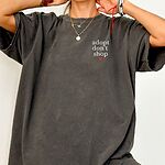 Woman in an oversized Pepper T-shirt embroidered with adopt don't shop in white stacked letters and a red heart on the left chest