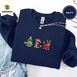 Navy crewneck sweatshirt folded with ripped jeans and a silver chain necklace, embroidered with three Bernese mountain dog puppies in a Christmas tree costume, a Santa hat with a red scarf and reindeer antlers with a red sweater