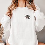 Woman in a White crewneck sweatshirt embroidered with a small Bernese mountain dog head in profile on the left chest
