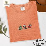 Terracotta Comfort Colors T-shirt embroidered with three tricolor Bernese mountain dog puppies in a Christmas tree costume, a Santa hat with a red scarf and reindeer antlers with a red sweater