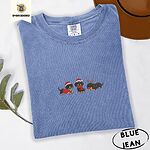 Blue Jean Comfort Colors T-shirt embroidered with three black and tan dachshunds in Santa hats, a red sweater, a red scarf and reindeer antlers