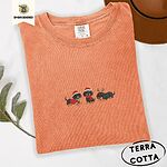 Terracotta Comfort Colors T-shirt embroidered with three black and tan dachshunds in Santa hats, a red sweater, a red scarf and reindeer antlers