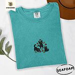 Seafoam Comfort Colors T-shirt embroidered with three black cats pouncing, leaping and sitting among falling red, orange and yellow autumn leaves