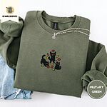 Military Green crewneck sweatshirt folded with light jeans and a silver chain necklace, embroidered with three black cats pouncing, leaping and sitting among falling red, orange and yellow autumn leaves