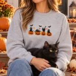 Woman wearing the black cats in pumpkins sweatshirt on a porch with her black cat