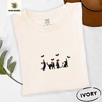 Ivory Comfort Colors T-shirt embroidered with four black cat silhouettes in Santa hats reaching for holly across the chest