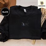 Black crewneck sweatshirt with a brown felt hat and dried bunny tail grass, embroidered with a black cat lounging with a glass of pink wine in the center of the chest