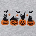 Close-up of the embroidered black cats in jack-o'-lanterns with bats and orange sparkles