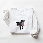 White crewneck sweatshirt laid flat, embroidered with a black Labrador carrying a red, white and blue flag