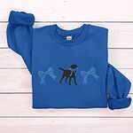 Royal crewneck sweatshirt laid flat on white wood, embroidered with a black Labrador silhouette with a ribbon bow at its neck between two large blue bows across the chest