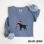 Blue Jean crewneck sweatshirt laid flat with rolled cuffs, embroidered with a black Labrador in a Santa hat carrying a string of Christmas lights
