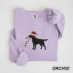 Orchid crewneck sweatshirt laid flat with rolled cuffs, embroidered with a black Labrador in a Santa hat carrying a string of Christmas lights