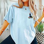 Woman wearing a Chambray T-shirt embroidered with a sitting black lab in bunny ears and a blue bandana with pink tulips, yellow flowers and a little bunny on the left chest