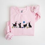 Light Pink crewneck sweatshirt laid flat, embroidered with four black lab silhouettes in bunny ears with a little bunny, Easter eggs, daffodils and a blue balloon