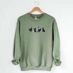 Military Green crewneck sweatshirt on a hanger, embroidered with four black lab silhouettes in bunny ears with a little bunny, Easter eggs, daffodils and a blue balloon
