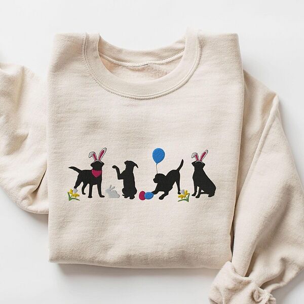 Sand crewneck sweatshirt laid flat, embroidered with four black lab silhouettes in bunny ears with a little bunny, Easter eggs, daffodils and a blue balloon