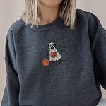 Woman in a Dark Heather crewneck sweatshirt embroidered with a black lab under a white ghost sheet with a jack-o'-lantern bucket