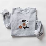 Sport Grey crewneck sweatshirt with rolled cuffs, embroidered with a black Labrador in a ghost sheet holding a jack-o'-lantern bucket beside three bats
