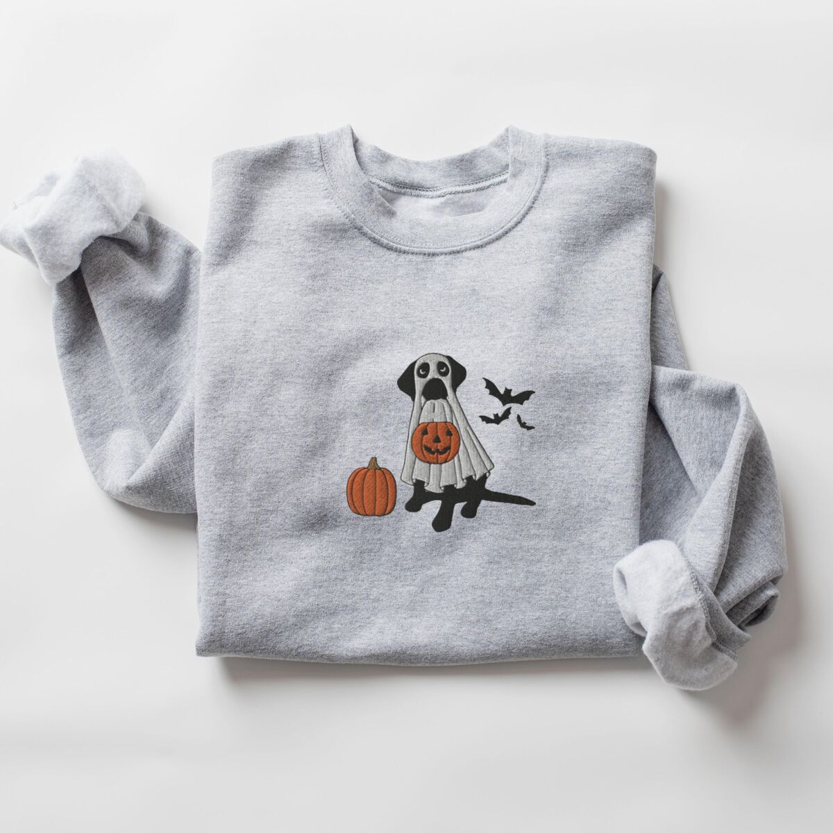 Black Lab Ghost Sweatshirt - Sport Grey Sport Grey crewneck sweatshirt with rolled cuffs, embroidered with a black Labrador in a ghost sheet holding a jack-o'-lantern bucket beside three bats