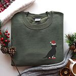 Military Green crewneck sweatshirt folded with red berries and pine cones, embroidered with a small black Labrador in a Santa hat and red booties on the left chest