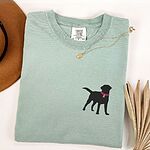 Bay T-shirt laid flat with a necklace, embroidered with a small black Labrador silhouette in a hot pink collar and tag on the left chest