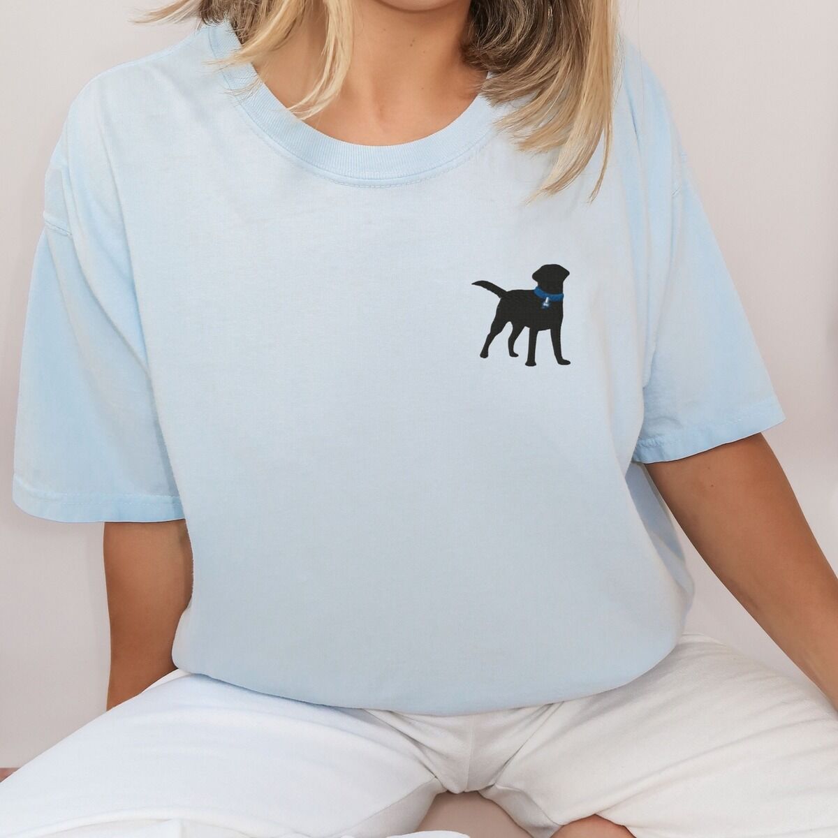Black Lab Silhouette Shirt - blue collar Woman in a pale blue T-shirt embroidered with a small black Labrador silhouette in a blue collar on the left chest