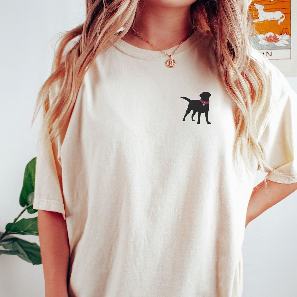Black Lab Silhouette Shirt - worn Woman in an Ivory T-shirt embroidered with a small black Labrador silhouette in a hot pink collar and tag on the left chest