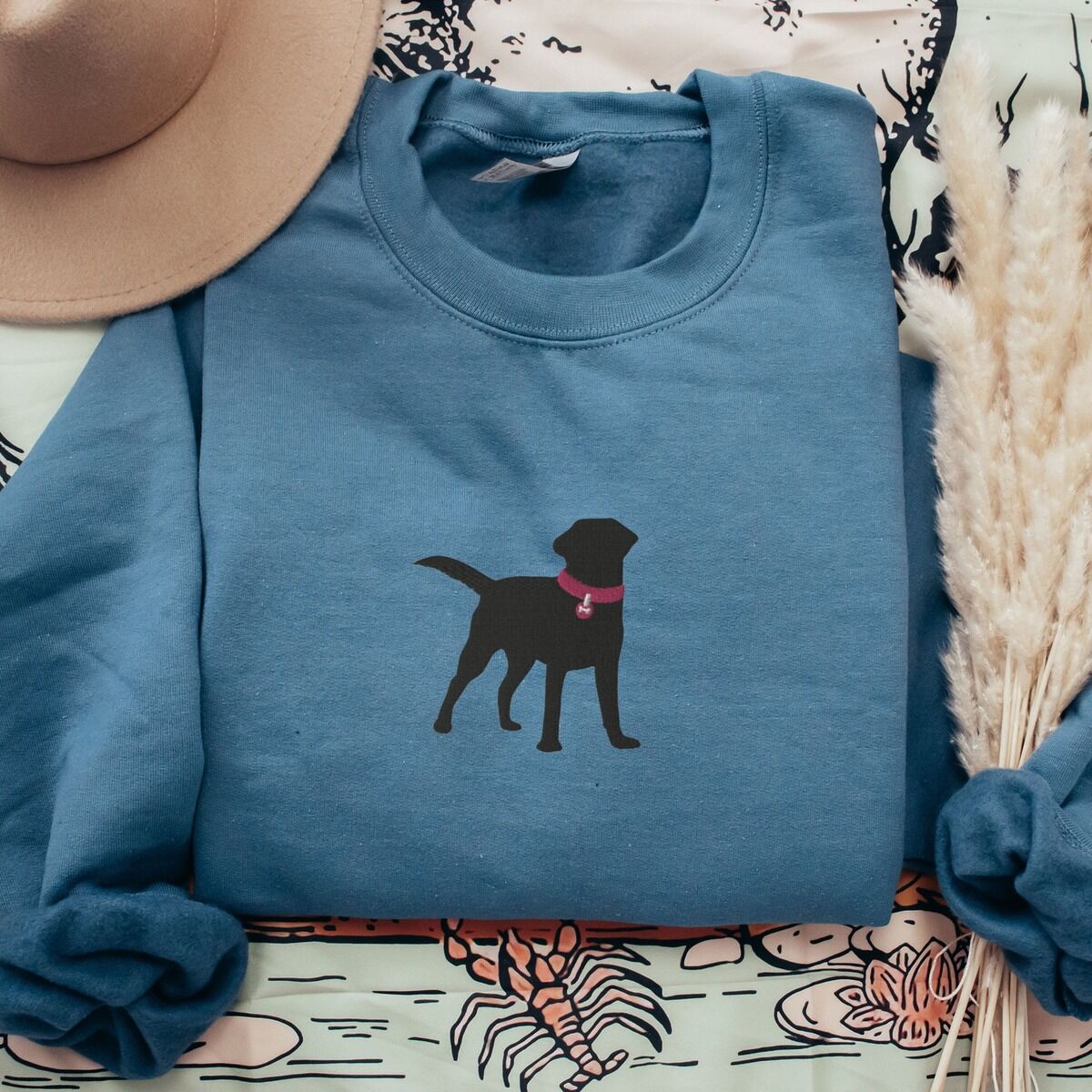 Black Lab Silhouette Sweatshirt - center chest Indigo Blue Indigo Blue crewneck sweatshirt with a hat and pampas grass, a larger black Labrador silhouette in a hot pink collar centered on the chest