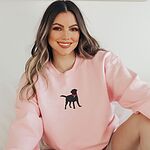 Smiling woman in a Light Pink crewneck sweatshirt with a black Labrador silhouette in a hot pink collar centered on the chest