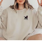 Woman in a Sand crewneck sweatshirt embroidered with a small black Labrador silhouette in a hot pink collar on the left chest